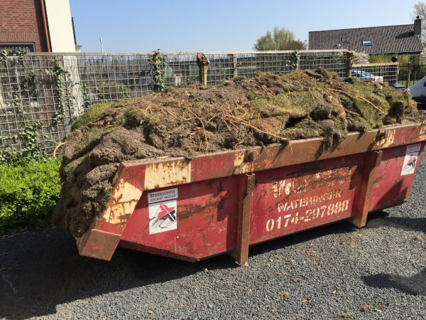 Verwijderde grasmatten in de afvalcontainer