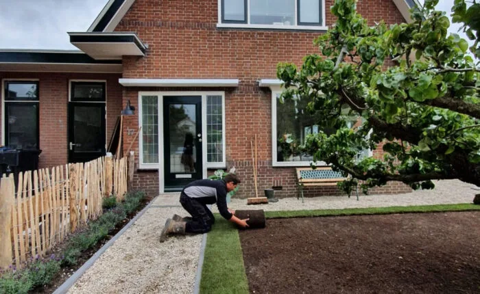 Tuinier Marccuna tijdens het leggen van grasmatten