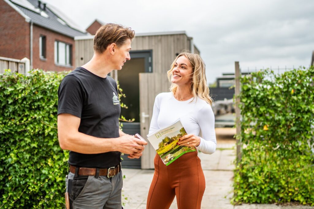 Klant in gesprek met tuinaannemer over service en garantie van grasmatten