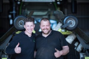 Twee collega’s van Graszodenkopen.be lachen en geven duim omhoog voor de camera