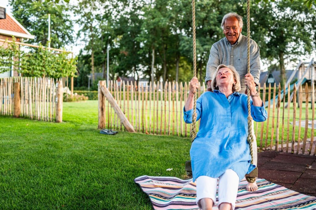 Vrouw op schommel in een tuin met grasmatten