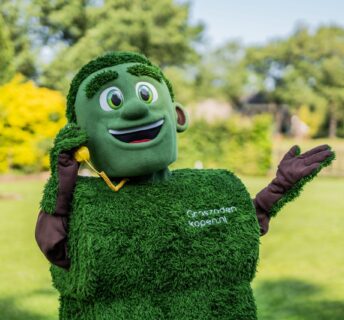 Grasmattie, de mascotte van Graszodenkopen.be, helpt behulpzaam aan de telefoon