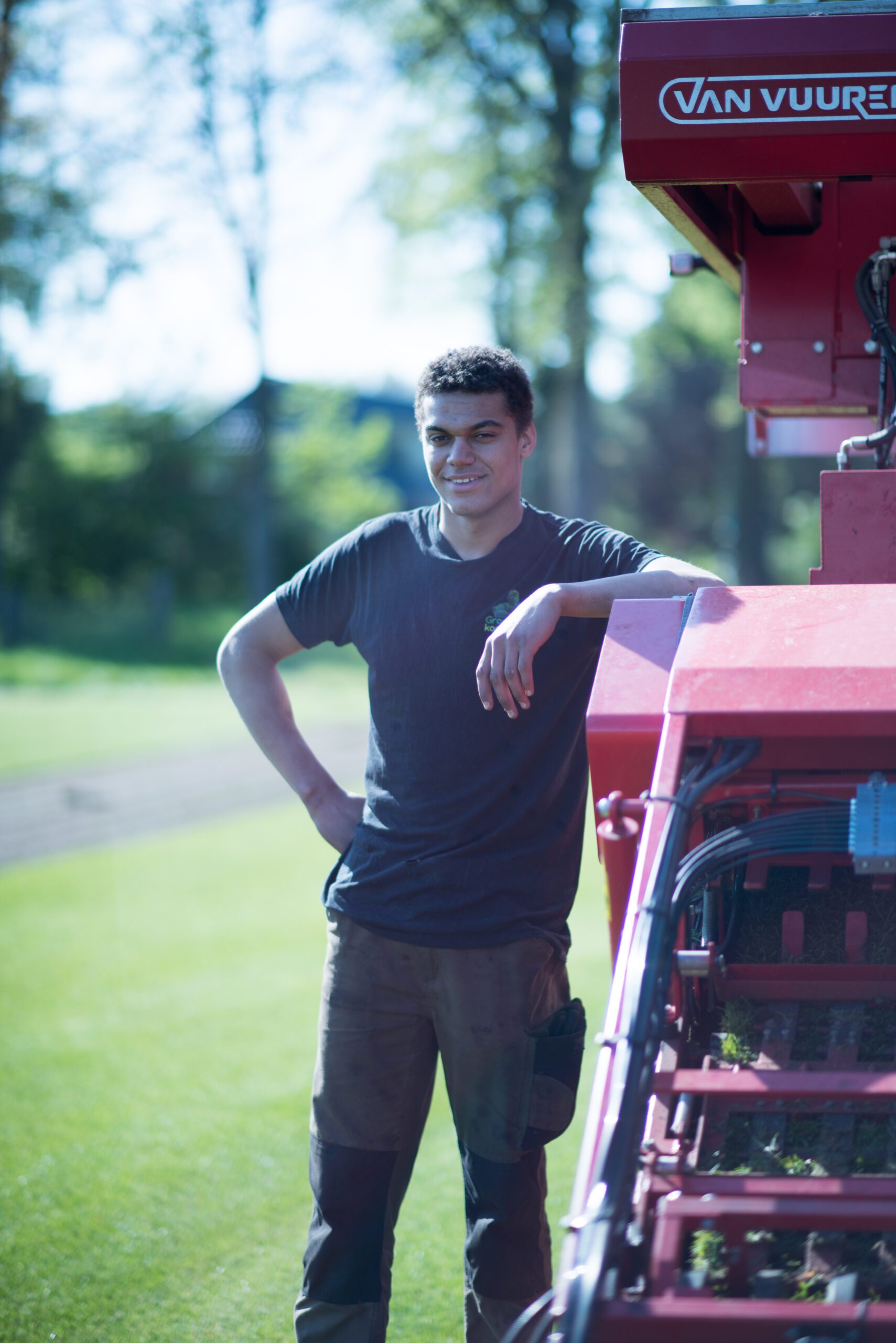 Medewerker van Graszodenkopen.be bij de grasmatten-oogstmachine op het veld