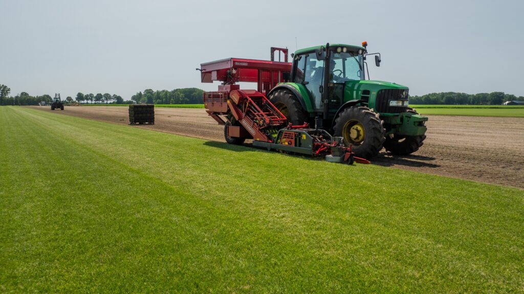Tractor snijdt duurzame grasmatten op het veld met een efficiënt oogstsysteem