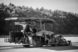 Medewerker van Graszodenkopen.be snijdt grasmatten met een machine op het veld