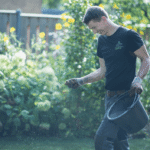 Hovenier strooit gazonmest over een gazon