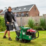 Medewerker van Graszodenkopen.be verwijdert oud gras met een snijmachine als voorbereiding op het leggen van nieuwe grasmatten.