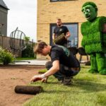 Vakman rolt grasmatten uit — bij 'Aanleg grasmatten'