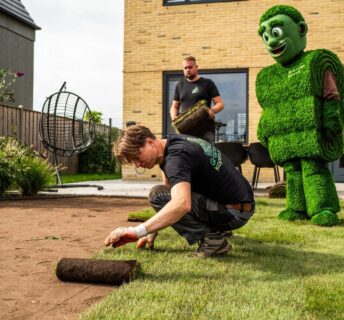 Vakman rolt grasmatten uit — bij 'Aanleg grasmatten'