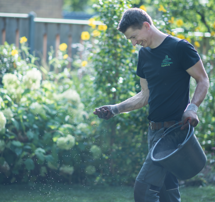Hovenier strooit gazonmest over een gazon