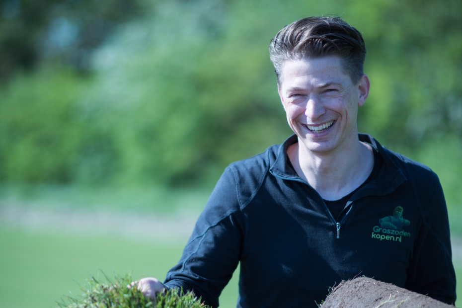 Medewerker van Graszodenkopen met een rol vers geoogste grasmatten