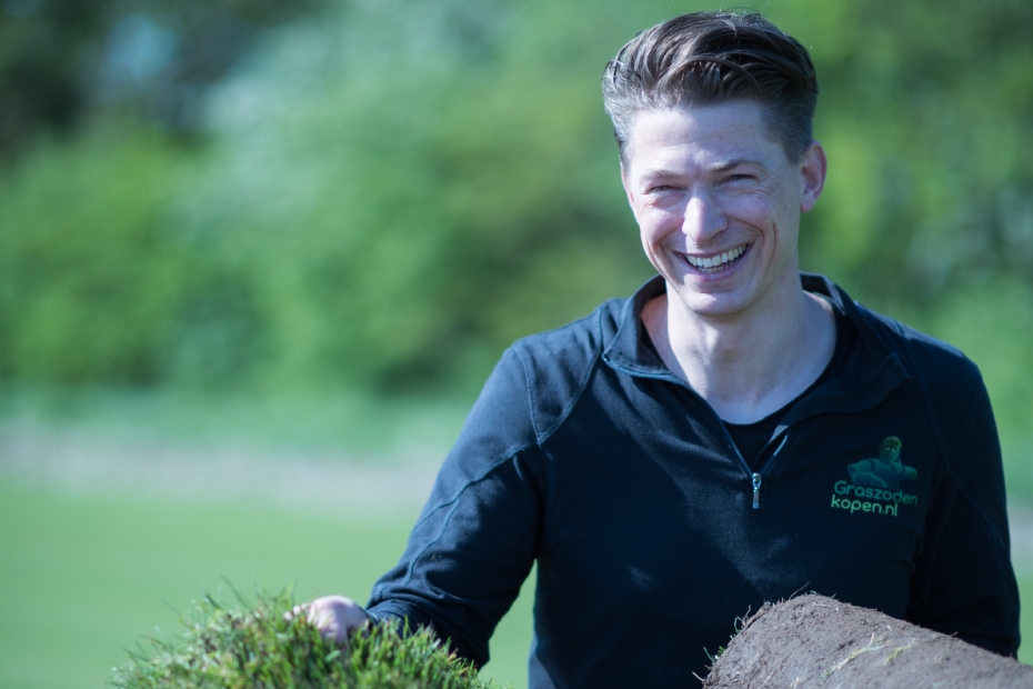 Medewerker van Graszodenkopen met een rol vers geoogste grasmatten