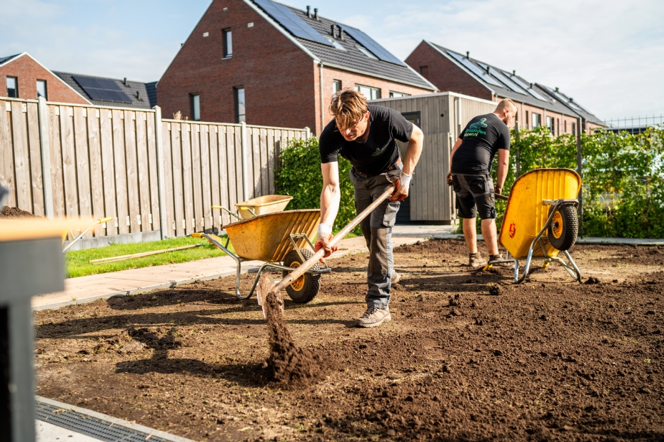 Hoveniers bereiden grond voor voordat grasmatten worden gelegd