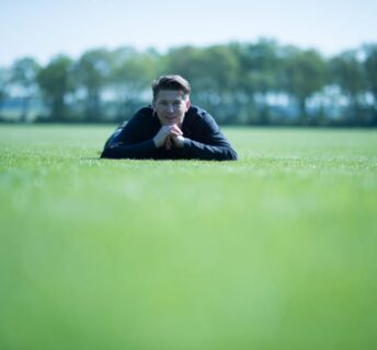 Medewerker controleert kwaliteit van een grasmattenveld