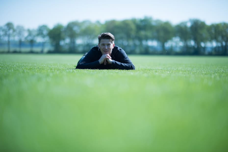 Medewerker controleert kwaliteit van een grasmattenveld